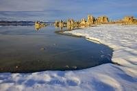 The curved, snow covered shoreline of Mono Lake leads towards a series of tufa towers for which the lake is famous.