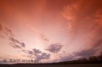 A field near Barrhead in Alberta with the after sunset light reflecting in the clouds above.