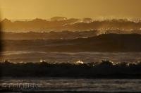 A spectacular sunset turns the ocean waves and sea spray into a boiling pot of gold.