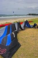 A surfing kite lays to rest on Orewa Beach, just north of Auckland, on the North Island of New Zealand, while others are already sailing.
