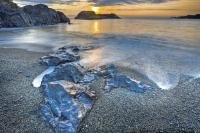 A surreal picture of water swirling around rocks set deep along the sandy coastal shores of South Beach in the Pacific Rim National Park on the West Coast of Vancouver Island at sunset.
