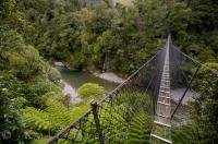 The Waiohine River has carved out a deep gorge where a swing bridge forms a gateway to the Tararua Forest Park in New Zealand.