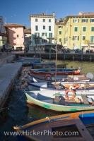 The Lake Garda waterfront in the town of Torbole in the Province of Trento, Italy is adorned with small boats of various colors.