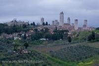 Multiple towers dominate the skyline in the medieval town of San Gimignano as seen from a distance, which is located in the Siena Province, in Tuscany Italy.