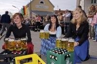 The ladies, while dressed in traditional dirndl's, serve steins of beer brewed in Bavaria, Germany.