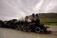 With the blow of her whistle the grand historic Kingston Flyer steam train pulls out slowly from Fairlight Station in Central Otago, New Zealand.