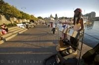 Equipped with drums, a busker entertains pedestrians along the harbour in the city of Victoria, British Columbia, Canada.