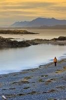 A woman takes a walk after sunset along South Beach located in the Long Beach Unit of the Pacific Rim National Park - part of the Clayoquot Sound UNESCO Biosphere Reserve. This park can be found on the West Coast of Vancouver Island in British Columbia.