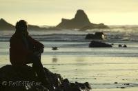 A woman enjoys the sunset on Ruby Beach during a vacation on the Olympic Peninsula in Washington, USA.