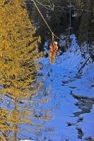 Zipling in the winter is an exhilarating experience as you whiz through the tree tops at high speeds. This person is ziplining across the Fitzsimmons Creek between Whistler and Blackcomb Mountains with Ziptreck Ecotours in Whistler, British Columbia.